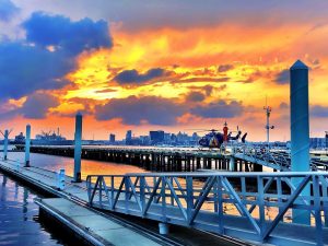 Overwater heliport base on Baltimore's waterfront at sunset with a Johns Hopkins helicopter on it.